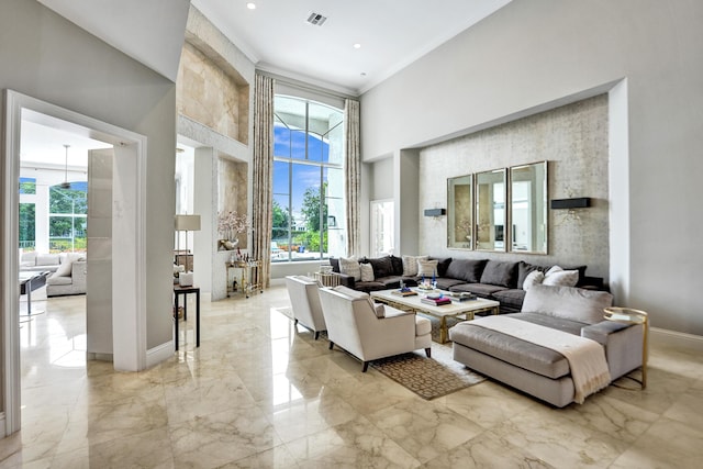 living room featuring a towering ceiling and ornamental molding