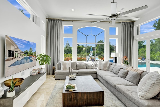 living room featuring french doors, ceiling fan, crown molding, and a high ceiling