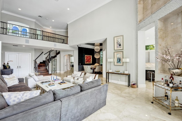 living room with ornamental molding and a high ceiling