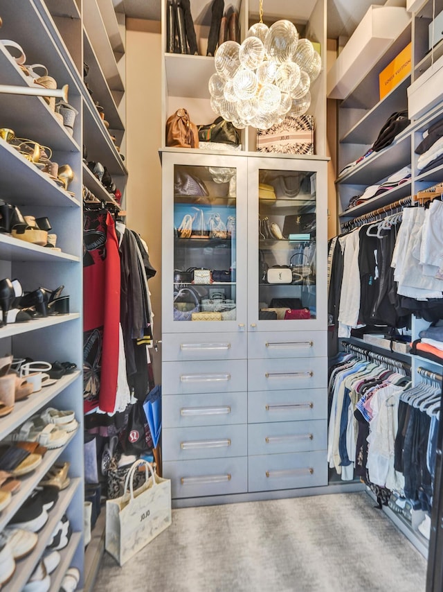 walk in closet featuring a chandelier