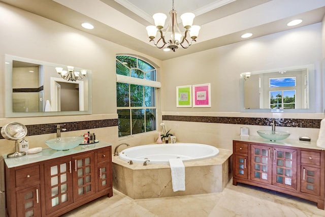 bathroom featuring vanity, a relaxing tiled tub, crown molding, and an inviting chandelier