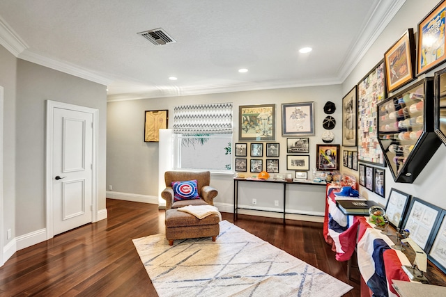 living area featuring dark hardwood / wood-style floors, baseboard heating, and crown molding