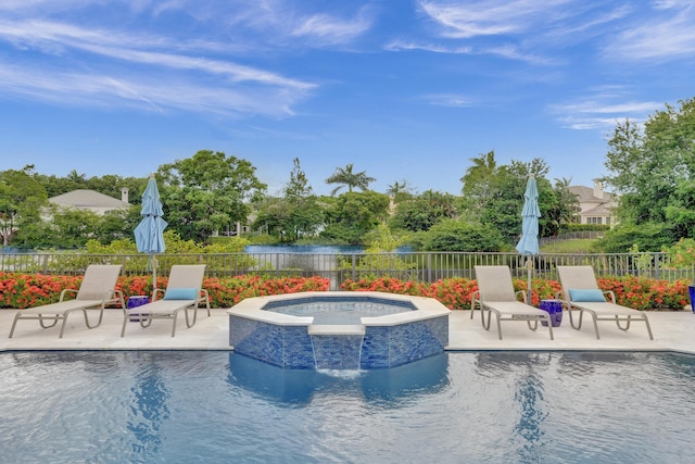 view of swimming pool featuring pool water feature, a water view, an in ground hot tub, and a patio