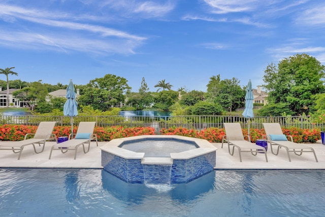 view of pool featuring a water view, an in ground hot tub, and a patio