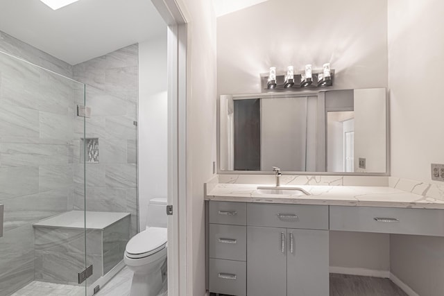 bathroom with walk in shower, vanity, and toilet