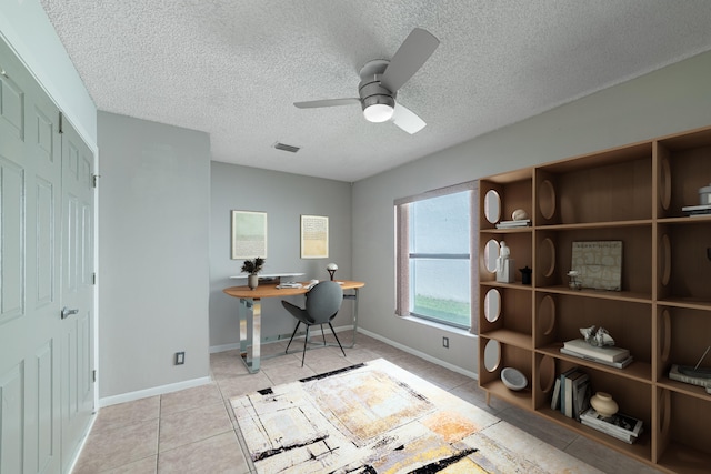 office area featuring ceiling fan, light tile patterned floors, and a textured ceiling