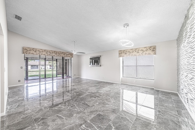 empty room with a textured ceiling, ceiling fan, and vaulted ceiling