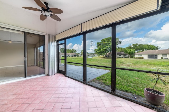 unfurnished sunroom featuring ceiling fan