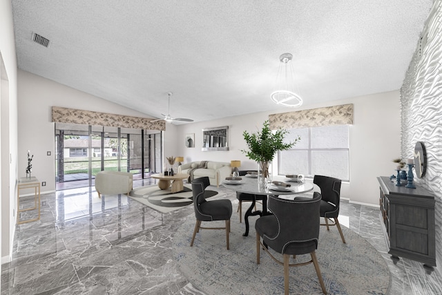 dining space with a textured ceiling, ceiling fan, and lofted ceiling