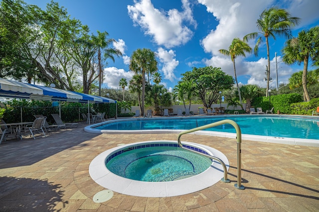 view of pool with a hot tub and a patio area