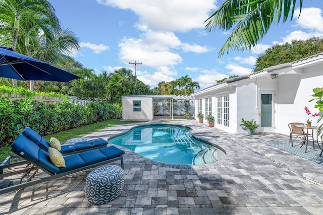 view of pool with a patio, an outdoor structure, and french doors