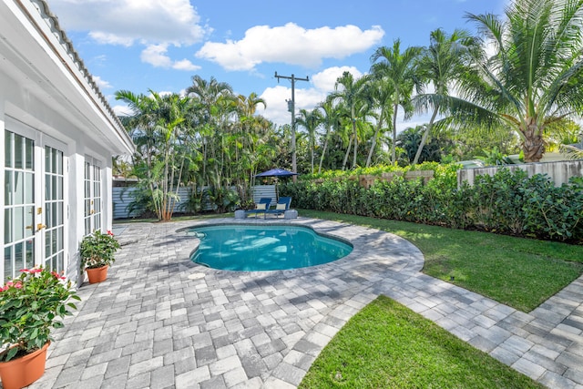 view of swimming pool with french doors and a patio