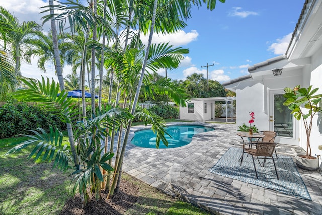 view of swimming pool featuring an outbuilding and a patio