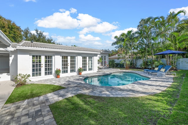 view of pool featuring a patio area, french doors, and a yard