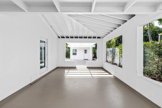 unfurnished sunroom with baseboard heating, a healthy amount of sunlight, and lofted ceiling with beams