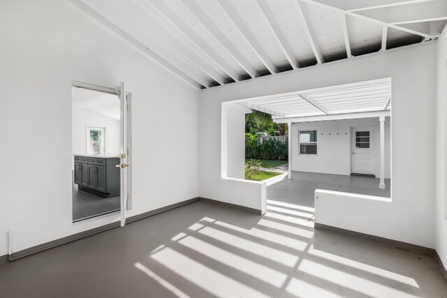 unfurnished sunroom with a healthy amount of sunlight and beam ceiling