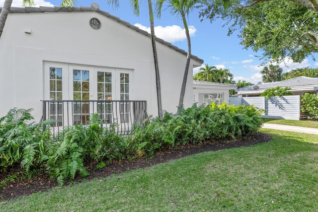 view of side of property with french doors and a yard