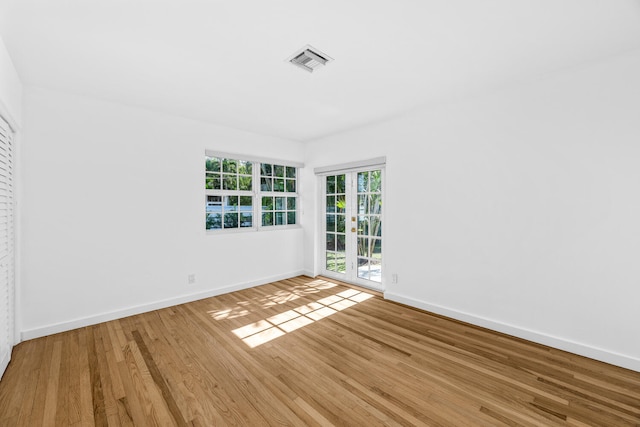 unfurnished room featuring french doors and light hardwood / wood-style floors