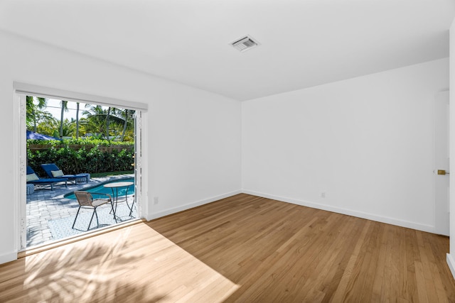 unfurnished room with hardwood / wood-style flooring