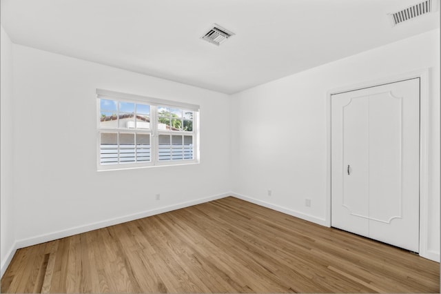 unfurnished bedroom with a closet and light hardwood / wood-style flooring