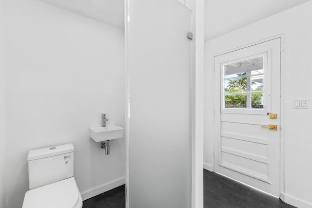 bathroom featuring toilet, sink, and hardwood / wood-style floors