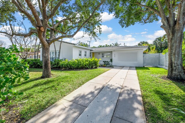 ranch-style house with a garage and a front yard