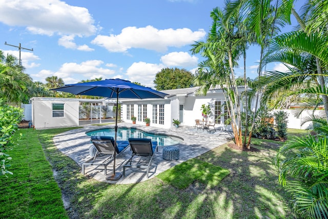 view of pool featuring a patio area, french doors, and a lawn