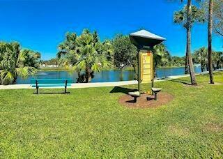 surrounding community featuring a lawn and a water view