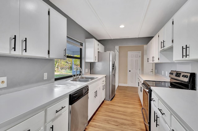 kitchen featuring white cabinetry, sink, light wood-type flooring, and appliances with stainless steel finishes