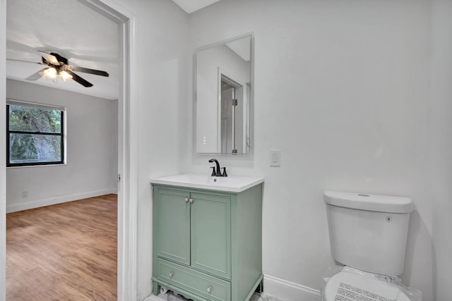 bathroom with ceiling fan, toilet, vanity, and hardwood / wood-style flooring