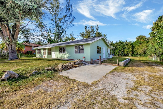 back of property with a lawn and a patio area