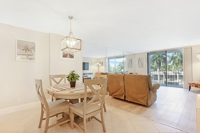 dining space featuring light tile patterned floors, baseboards, expansive windows, and a chandelier