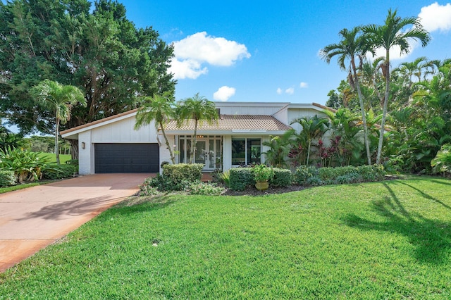 single story home featuring a front yard and a garage