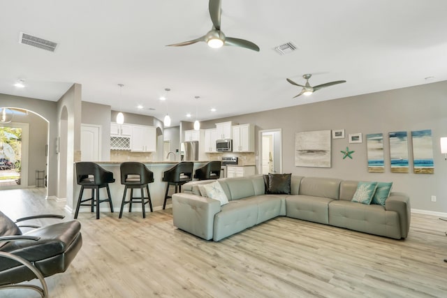 living room featuring ceiling fan and light wood-type flooring