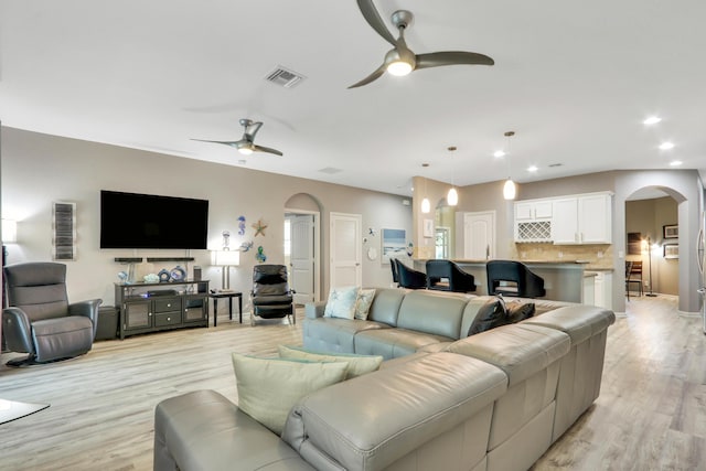 living room featuring ceiling fan and light hardwood / wood-style flooring