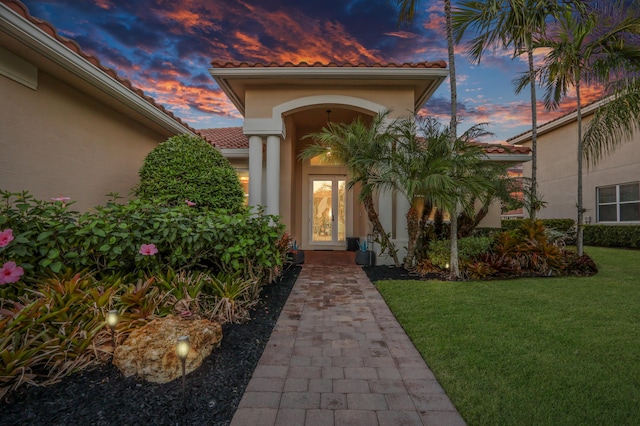 exterior entry at dusk with a lawn