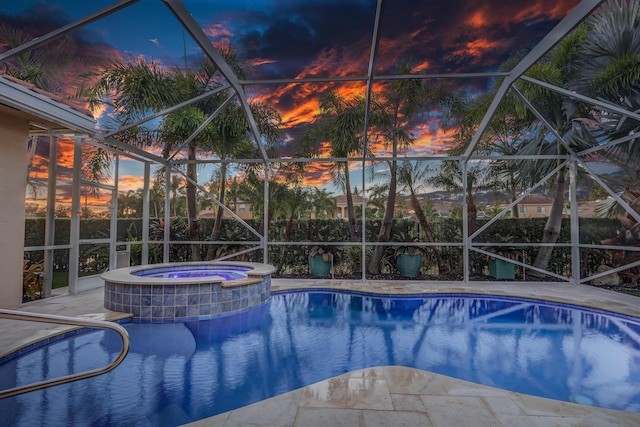 pool at dusk with an in ground hot tub, a lanai, and a patio