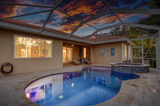 pool at dusk featuring ceiling fan, glass enclosure, and a patio