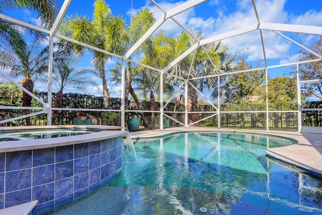 view of swimming pool featuring a patio, glass enclosure, and an in ground hot tub