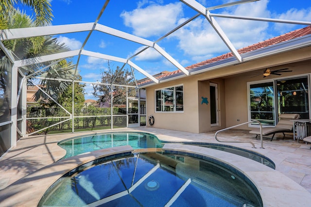 view of swimming pool featuring an in ground hot tub, a lanai, ceiling fan, and a patio