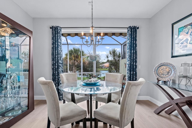 dining space featuring plenty of natural light, light hardwood / wood-style floors, and an inviting chandelier