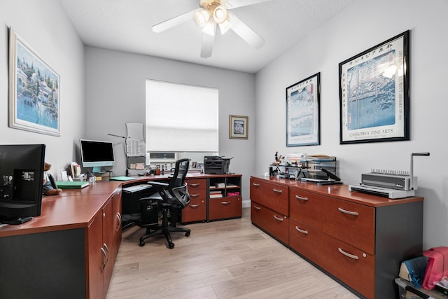 home office with ceiling fan, light hardwood / wood-style floors, and a textured ceiling