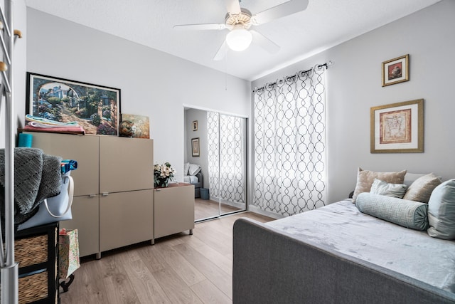 bedroom featuring a textured ceiling, a closet, light hardwood / wood-style flooring, and ceiling fan