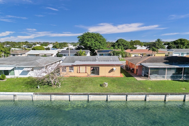 rear view of property with a yard and a water view