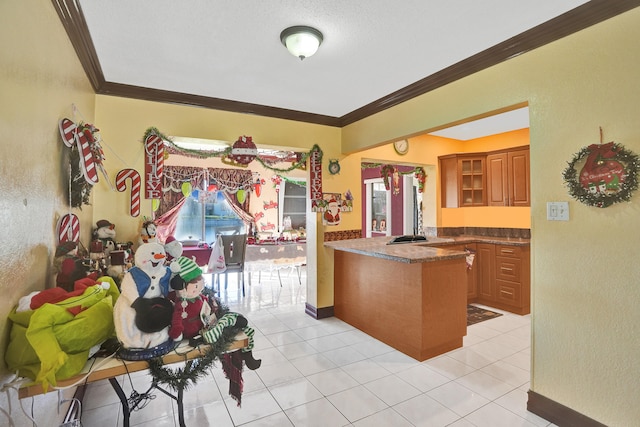 kitchen featuring kitchen peninsula, light tile patterned floors, a textured ceiling, and ornamental molding