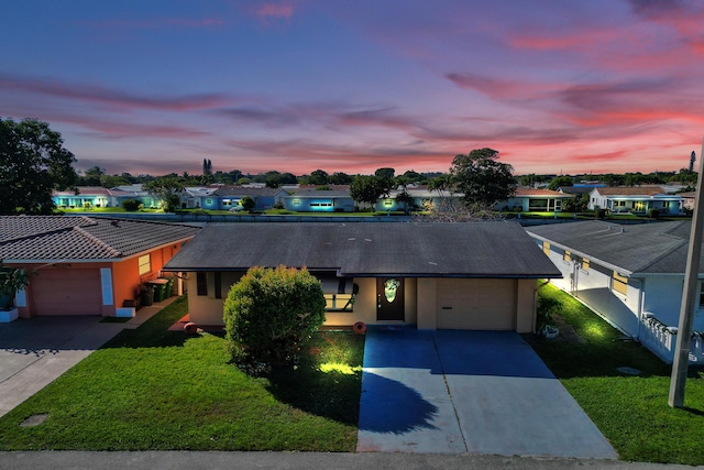 view of front of property with a yard and a garage