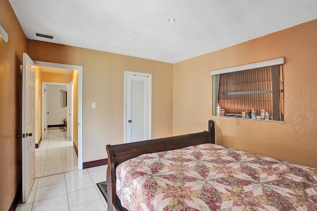 tiled bedroom with a closet