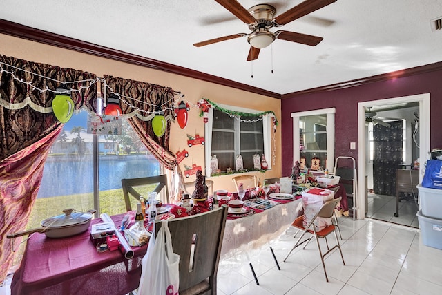 dining area with ceiling fan, tile patterned floors, a textured ceiling, a water view, and ornamental molding