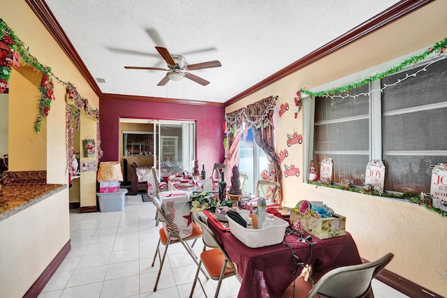 tiled dining room featuring ceiling fan, crown molding, and a textured ceiling