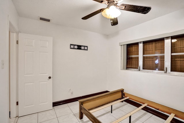 unfurnished bedroom with ceiling fan and light tile patterned floors